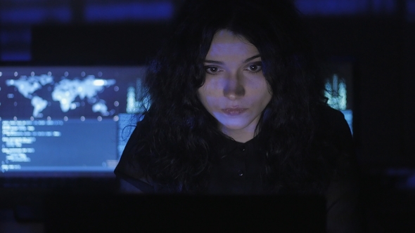  Young Woman Programmer Working at a Computer in the Data Center Filled with Display