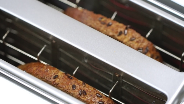 Overcooked and Burnt Toast Bread Popping up from White Toaster Machine