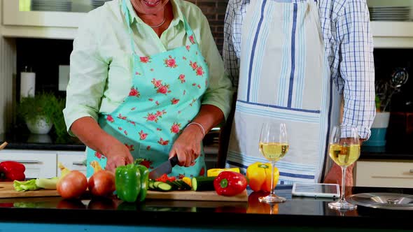Senior couple cutting vegetables in kitchen 4k