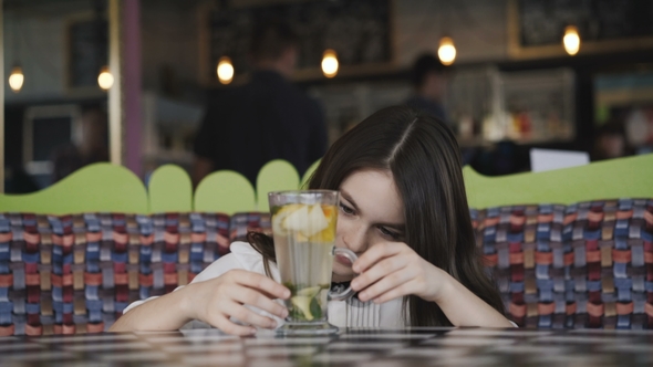 Pretty Girl Admiring of Lemonade's Serving in Cafe