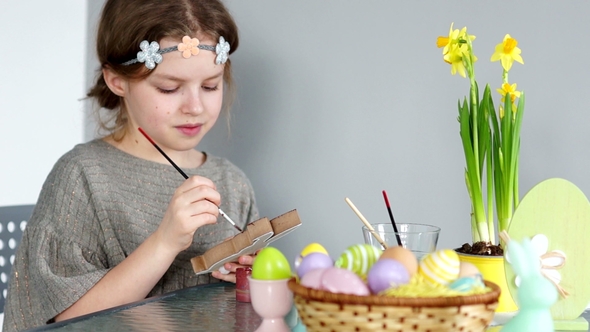 Preparation for Easter. The Daughter Paints the Easter Bunny. Children's Creativity. Art Therapy