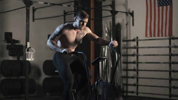 Shirtless Sportsman Training on Cycle