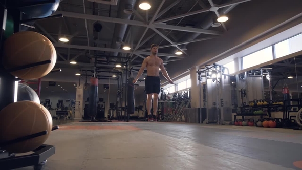 Athlete Man Doing Exercises with Skipping Rope on Crossfit Training in Club