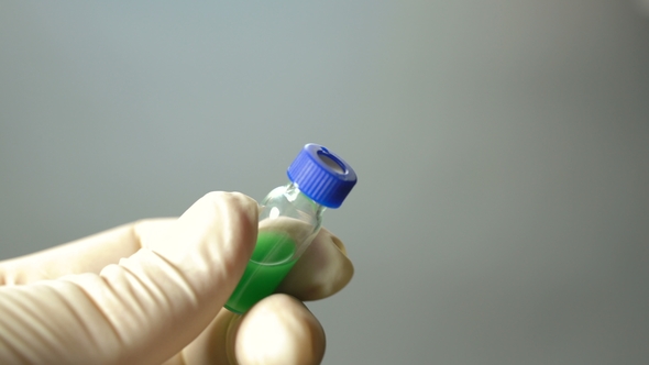 The Scientist Opens a Vial of Liquid and Collects It in a Syringe