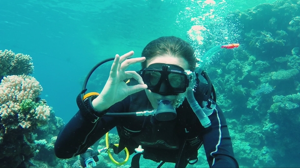 Great Vacation and Diving in the Warm Sea. The Scuba Diver Signs the Okay Sign and Takes Himself Off