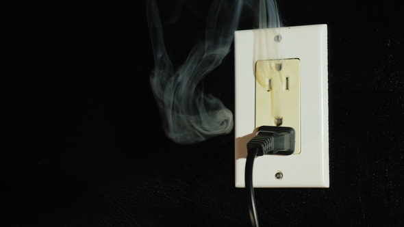 The Beginning of the Fire in an American Type Socket. Smoke Streams Come From a Double Home Outlet -