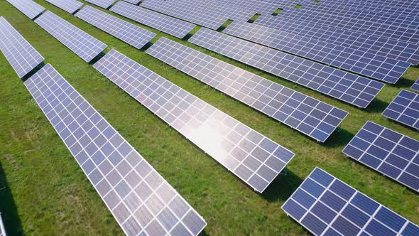 Flight Over a Field of Solar Panels in Sunny Summer Day