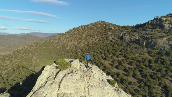 Man Is Standing on Top of Rocky Cliff javascript Aerial View. Drone Is Distancing Reveal Shot