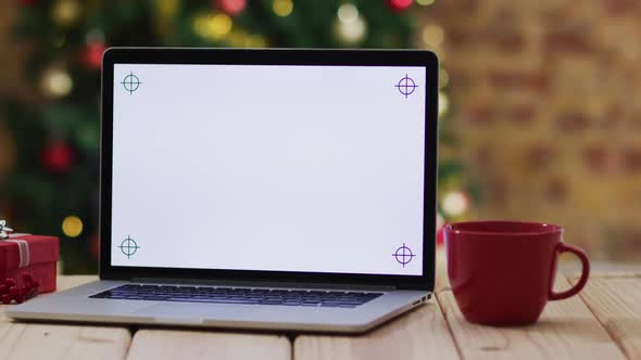 Video of wooden table with laptop over christmas tree