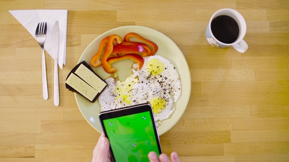 Male Hands Shooting an Omelette with a Tablet