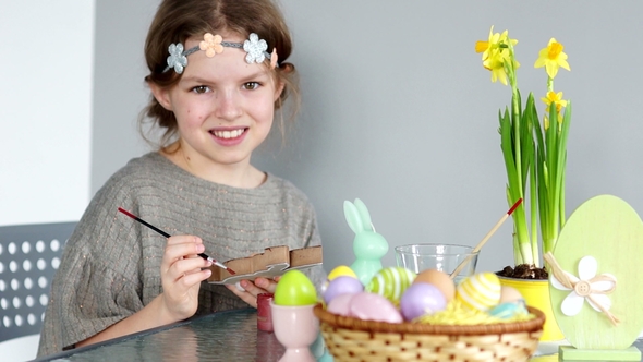 A Brown-eyed Girl with a Wreath on Her Head Is Preparing for Easter. The Child Looks at the Camera