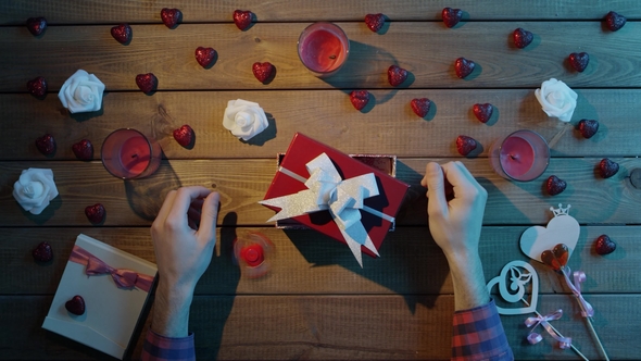 Adult Man Puts Spinner Into the Gift Box As Holiday Present, Top View