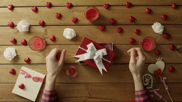 Young Man Puts Spinner Into the Gift Box As Holiday Present, Top View