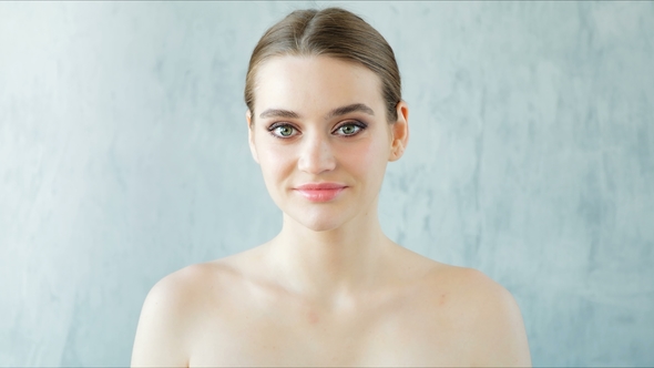 Beautiful Young Woman with Perfect Fresh Skin Looking at Camera. Skincare Concept