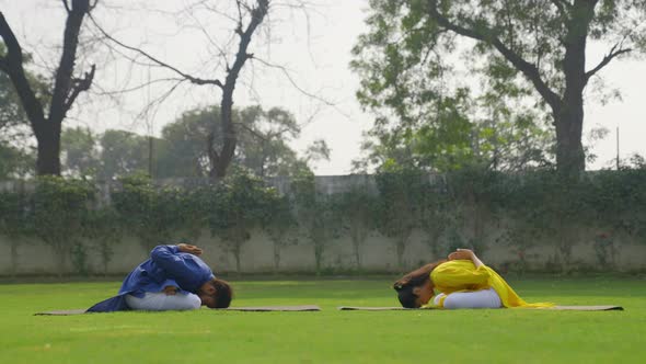 Padmasana with forward bend Yoga is being done by an Indian couple in an Indian outfit