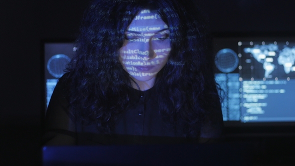 Woman Hacker Programmer with Curly Hair Is Working on Computer
