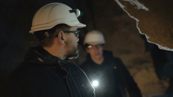 Two Speleologists Exploring the Cave's Calcareous Wall