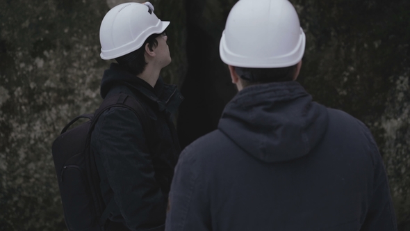 Two Speleologists Talking at Enter of the Cave in Forest