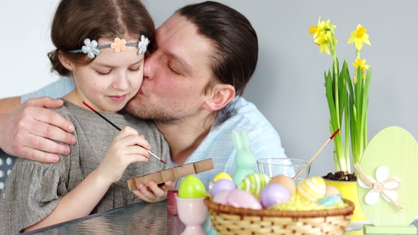 Easter Traditions. Dad and Daughter Decorate the Figure of the Easter Bunny. Papa Gently Kisses the