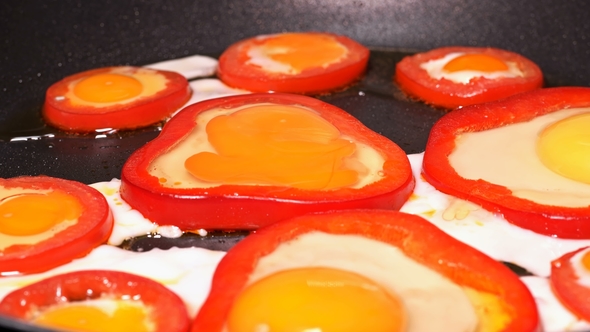 Eggs Laid Out in Peppers Are Fried in a Pan