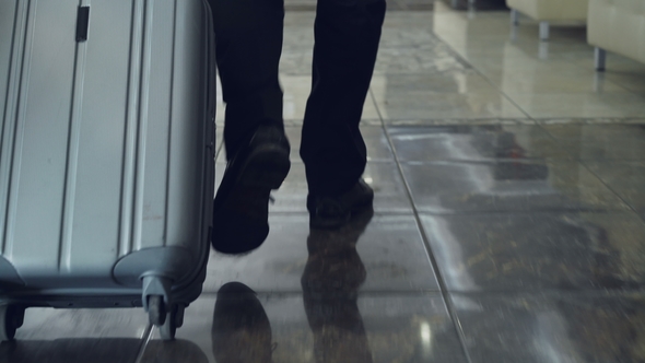 Dolly Shot of Legs of Businessman Walking Through Hotel Lobby Pulling Luggage and Stop at Reception