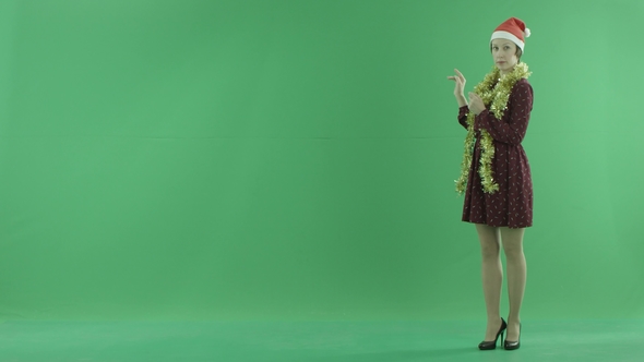 A Young Christmas Woman Is Talking About the Weather Forecast on the Right Side of the Green Screen