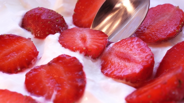 Piece of Strawberry Is Taken From Cream By Spoon.