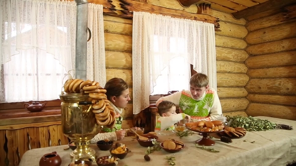 Family with a Child Drinking Tea and Eating Pastry in a Russian Wooden Bath