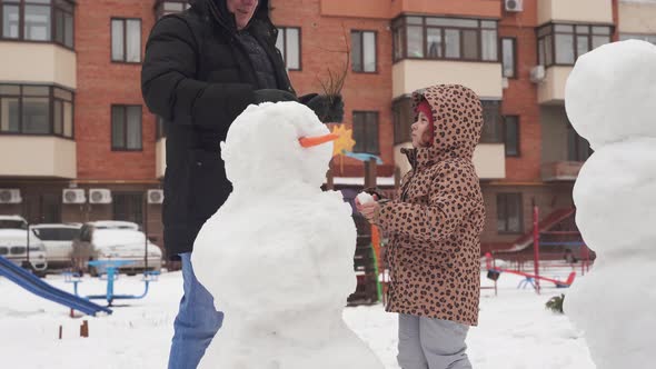 Father and Child Playing on Winter Snowy Day