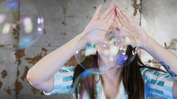 Woman Blowing Through Her Hands Soap Bubbles