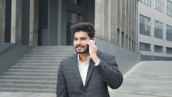 Portrait of Positive Arabian Man in Formal Wear Having Mobile Conversation While