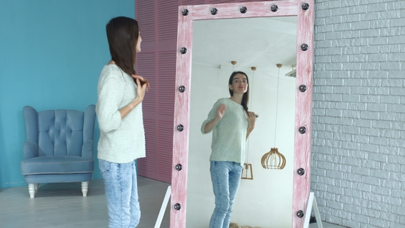 Elegant Woman Admiring Herself Reflection in Mirror