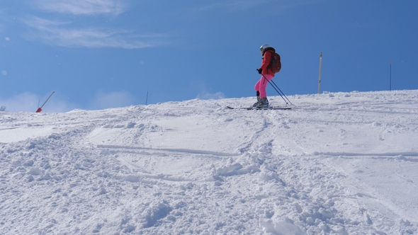 Woman Slowly Rolls Down The Mountain Skiing On A Steep Slope With Boulders