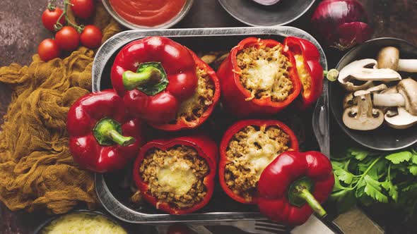 Red Bell Stuffed Paprika Peppers in Iron Cooking Pot with Various Ingredients on Side