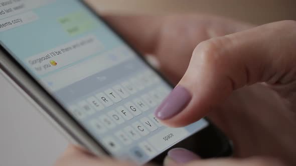 Close-up of Female Fingers Write Message on Smartphone To a Friend