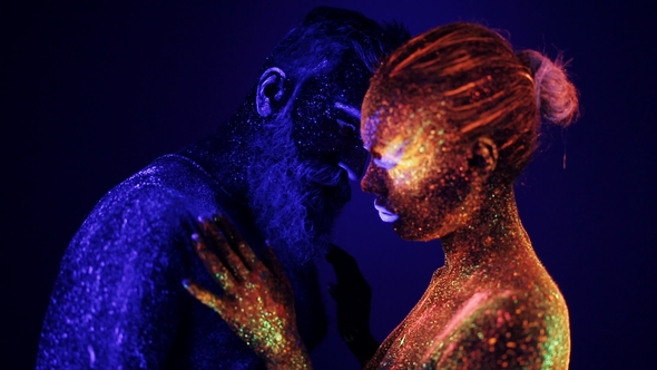 A Man and a Woman in the Ultraviolet Light Caress Each Other