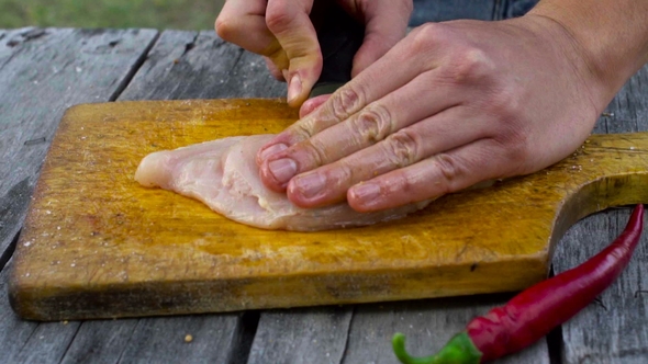 Man Cut Chicken Into Steaks on Backyard