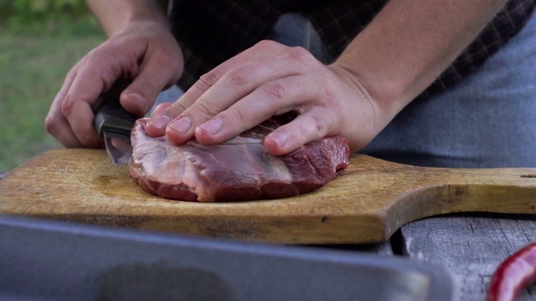 Man Cut Meat Into Steaks on Backyard.  Shoot