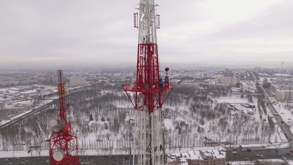 Workers Climbing on a Telecom Tower while Others Performing Repairs alt