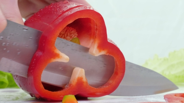 Knife Cuts the Red Pepper. A Large Red Sweet Pepper Is Cut on a Cutting Board