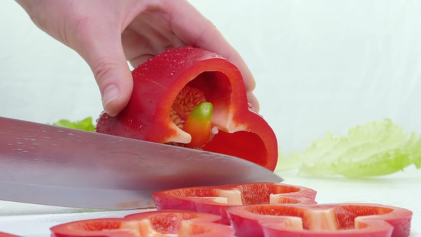 Knife Cuts the Red Pepper. A Large Red Sweet Pepper Is Cut on a Cutting Board. , Side View