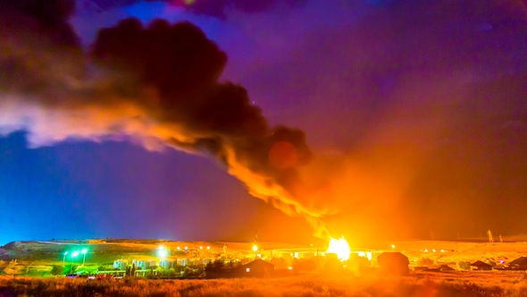 Fire at an Oil Refinery, at Night During a Thunderstorm