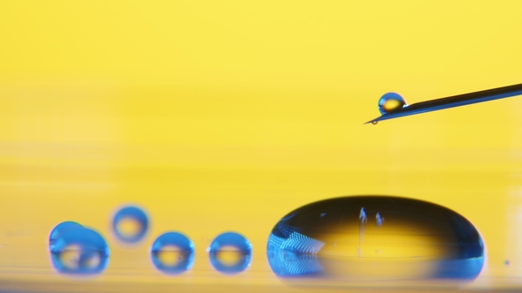 Small Dribs of Water Fall From a Syringe and Roll Making a Small Pool