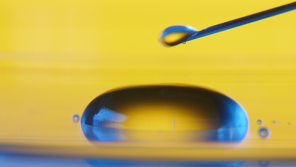 Small Dribs of Water Fall From a Syringe and Roll Making a Small Pool