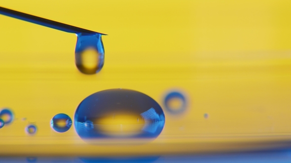 Transparent Drops of Water Plash From a Syringe Forming a Small Pool