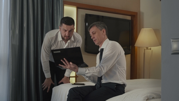 Businessmen Coworking in Hotel Room with Gadgets