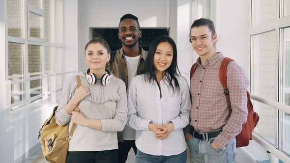 Portrait of Four Positive Multi-ethnic Male and Female Students Standing in Spacious White Corridor