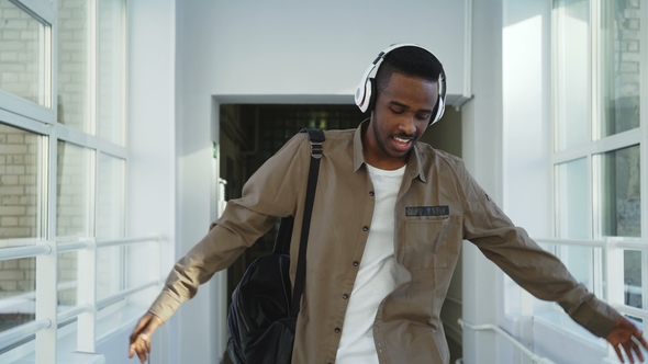 Young Handsome African-american Student Walking Dancing in White Corridor of College