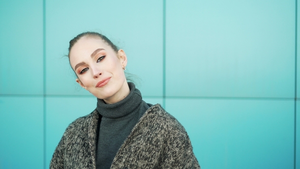 Portrait of Young and Fresh Brunette Girl with Big Eyes Looking at Camera and Smiles Happily