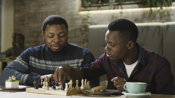 Content Black Men Playing Chess in Cafeteria